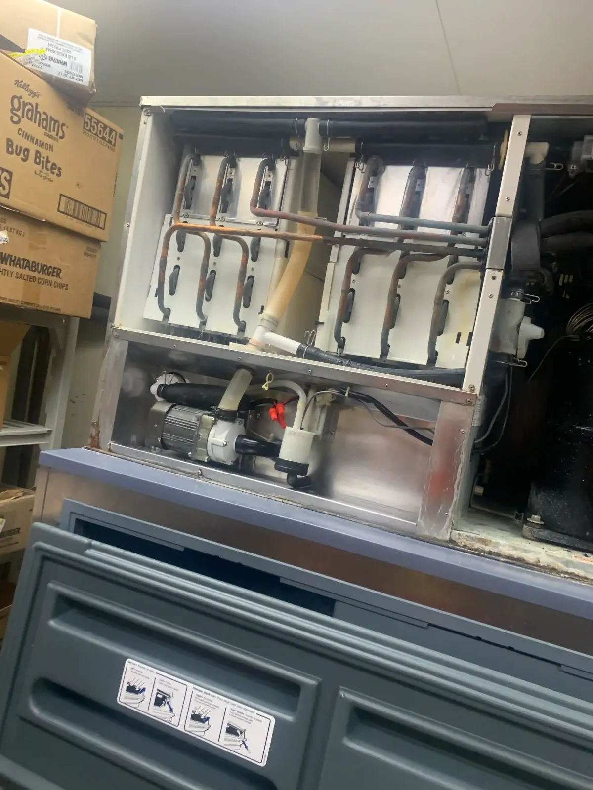 Modern stainless steel commercial refrigeration unit with glass doors in a clean food storage area featuring organized produce, bright lighting, and professional kitchen elements