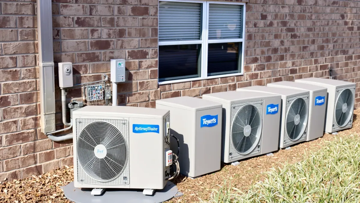 Freshly serviced, fully functional outdoor air conditioning unit on a concrete pad in a landscaped yard in Burleson, TX.