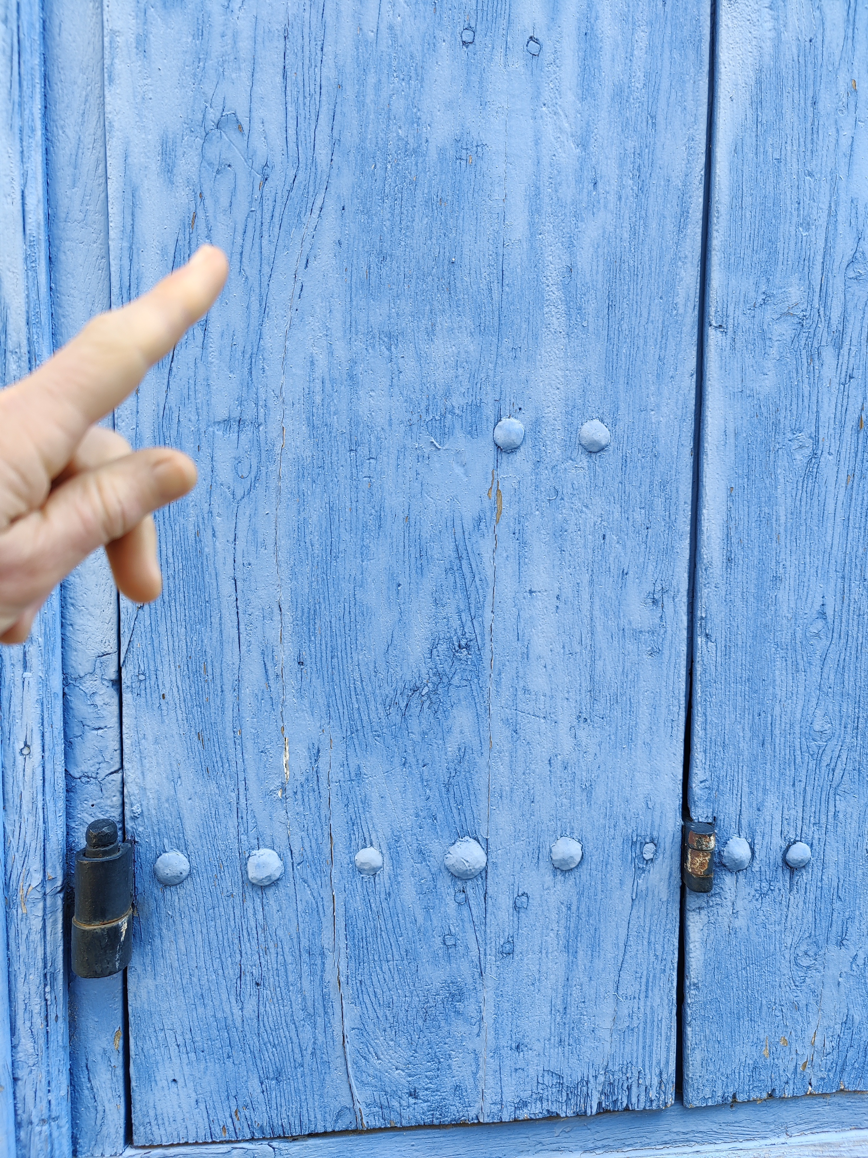 Independent French real estate consultant's finger pointing at a historic French door