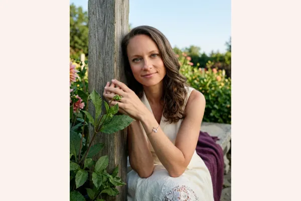 Woman on a garden bench with a composed smile, illustrating how to explain a layoff in an interview