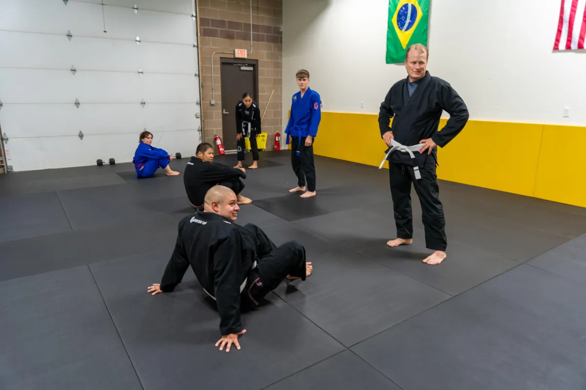 Introductory Brazilian Jiu-Jitsu class at Mountain Rollers Jiu-Jitsu in Colorado Springs, featuring a mix of new and experienced students learning foundational techniques in a supportive and friendly environment. The class is led by an instructor wearing a white belt, symbolizing the gym's commitment to welcoming beginners and fostering growth at all levels. Mountain Rollers Jiu-Jitsu offers high-quality BJJ training for individuals of all ages and experience levels in Colorado Springs.