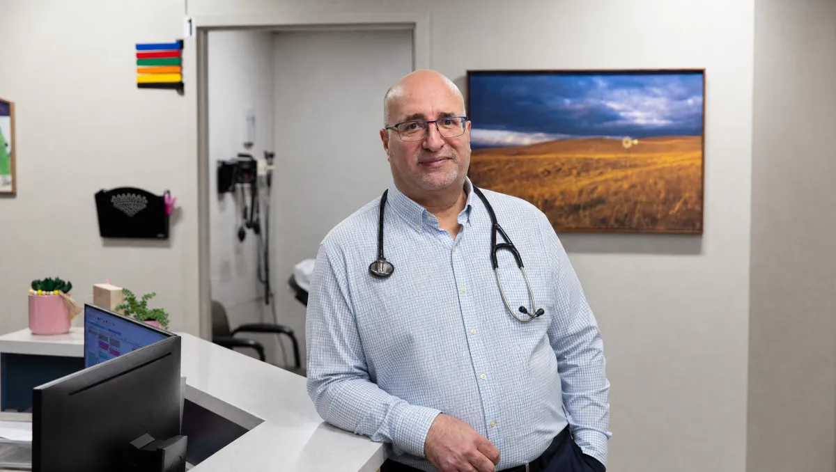 Dr. Maen Haddadin, smiling in white coat, standing in a clinic office in Omaha Nebraska. 