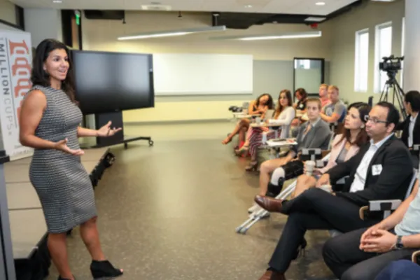 Woman presenting to a group of entrepreneurs at a 1 Million Cups community event.