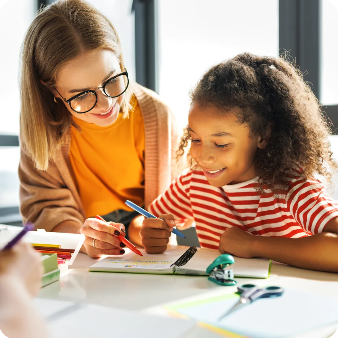 Tutor helping a smiling child with homework, representing Joy Tutoring’s personalised services in Pinelands, Cape Town or online across South Africa.