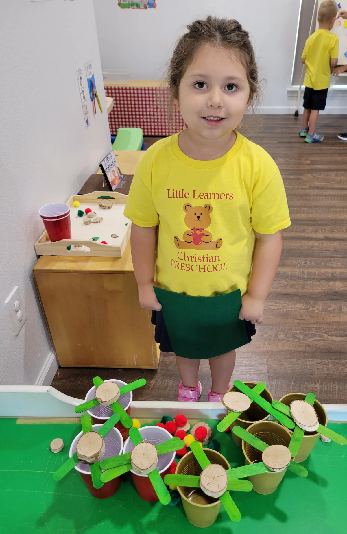 Boy picks paper out of different colored liquids