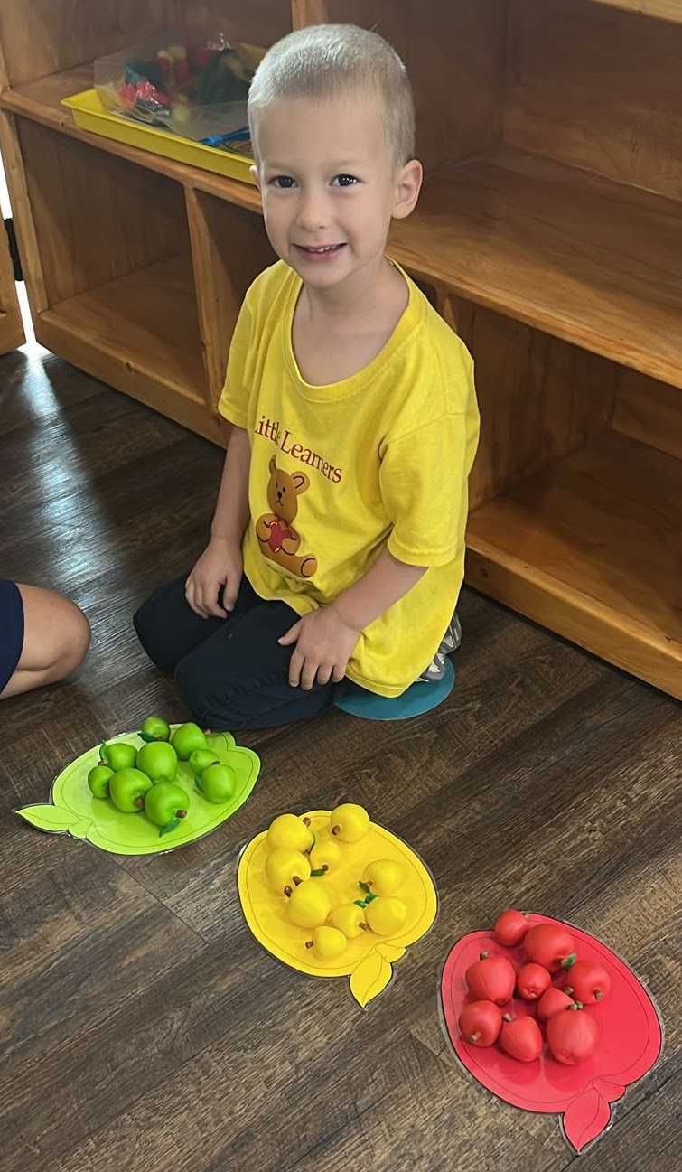 Girl stretches to the side while watching teacher on large screen TV
