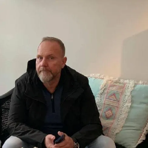 Portrait of Viggo E. Emundsen, Norwegian male, 50s, formal suit, confident, gold-toned background, 3:2 aspect