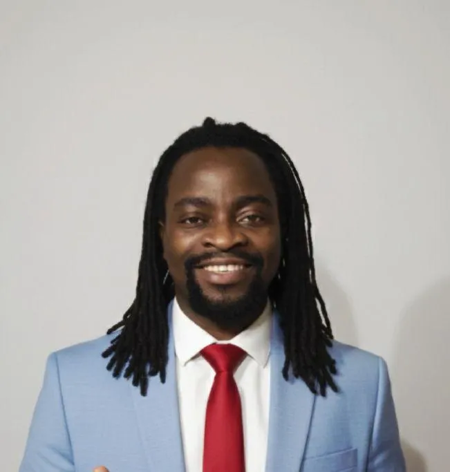 Portrait of Buyinza Julius/Barbi Jay, African male, 30s, creative, gold-accented background, 3:2 aspect