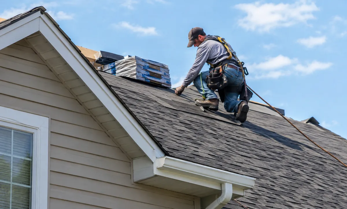 Roof replacement contractor installing new asphalt shingles on a residential home in Rochester Hills, Michigan.