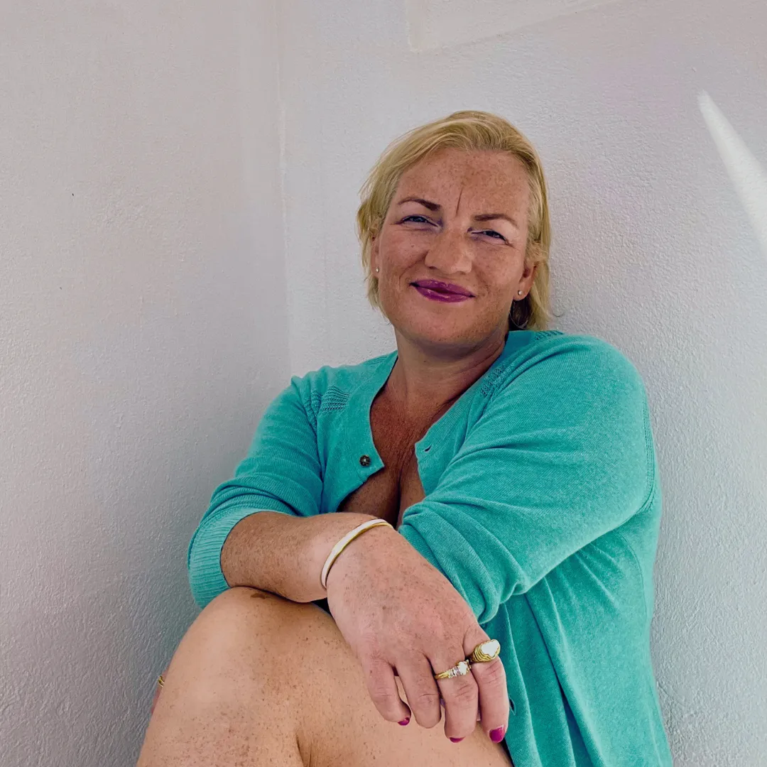 Caroline James smiling on a beach making a peace sign. Spiritual Entrepreneur for Women. She Can Shine.