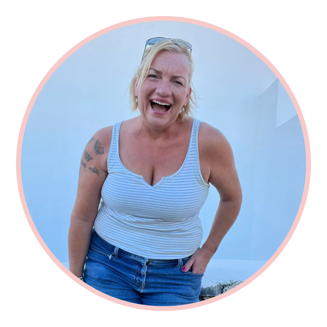 Caroline Harland smiling wearing blue heart dress on a bench. Spiritual Somatic Coach for Women. She Can Shine.
