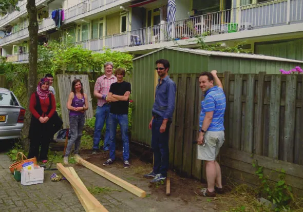 Even poseren voor de foto, dan weer verder met de werkzaamheden in de tuin - wijk Buitenhof in Delft
