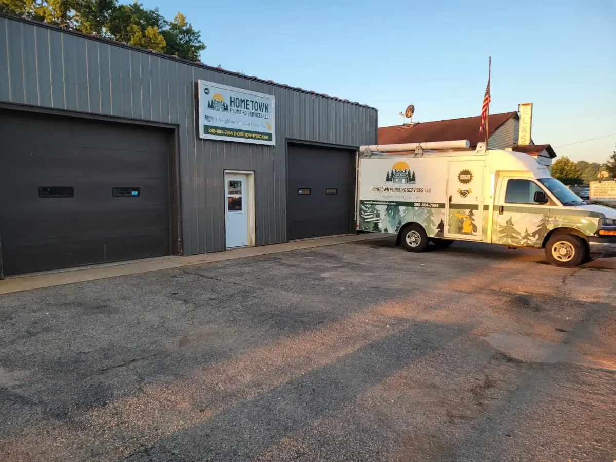 Exterior view of the Hometown Plumbing Services building with a branded repair van and truck parked in the lot.
