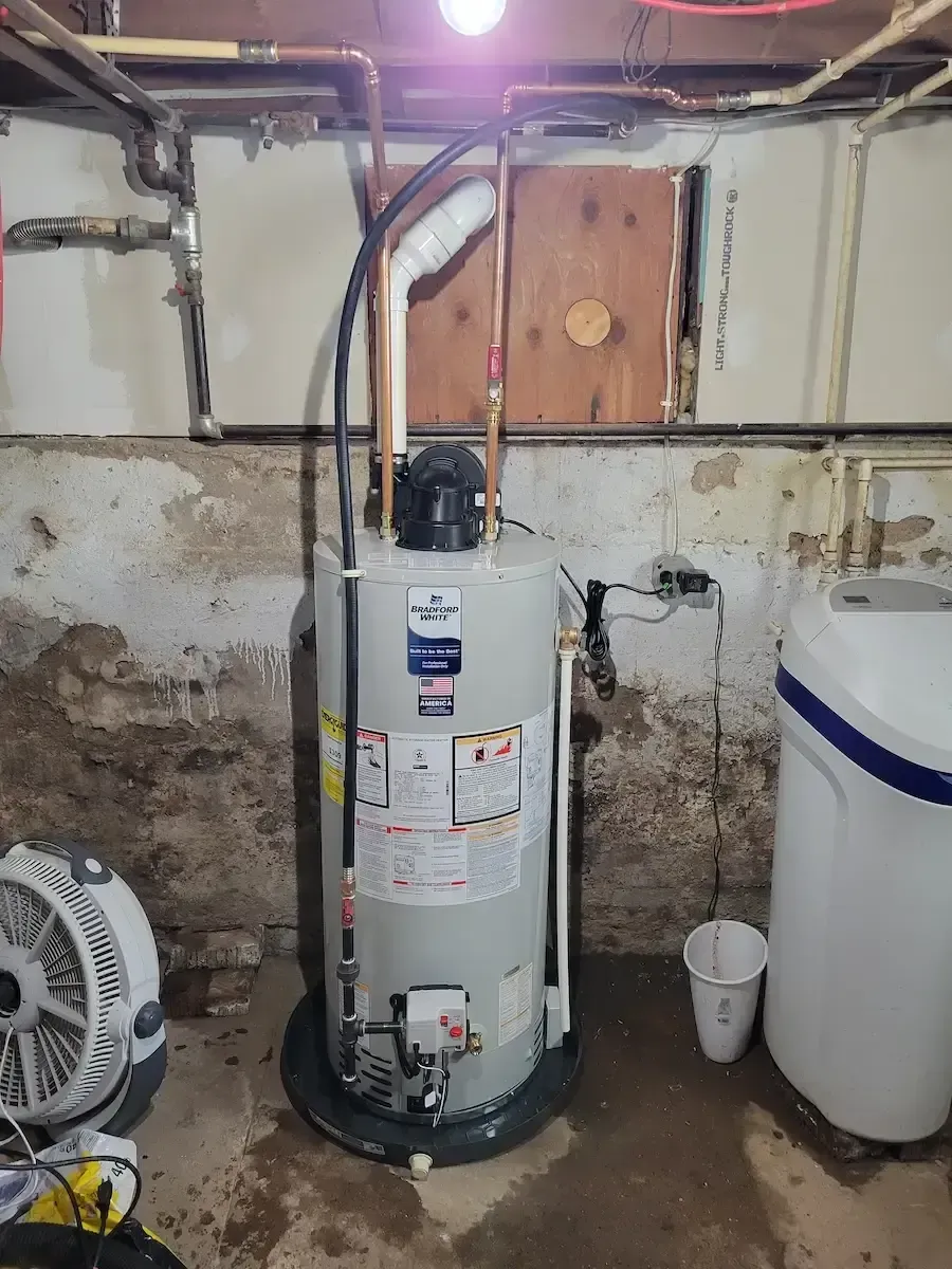 New Bradford White water heater installed alongside an iron and sulfur filtration system to provide clean, odor-free hot water in a Barry County home.
