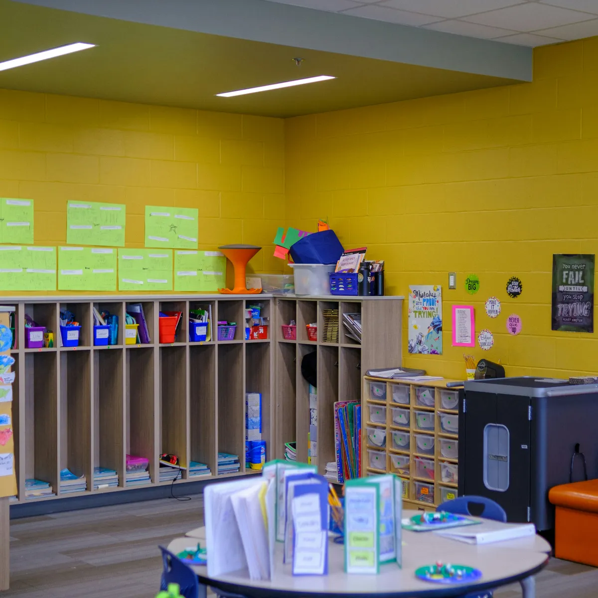 an empty classroom with wooden desks and windows