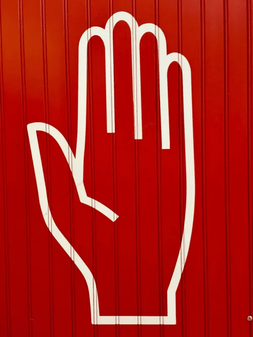 A hand with red background indicating a stop signal