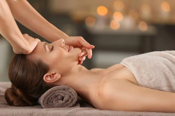 Side view of a woman receiving a facial.