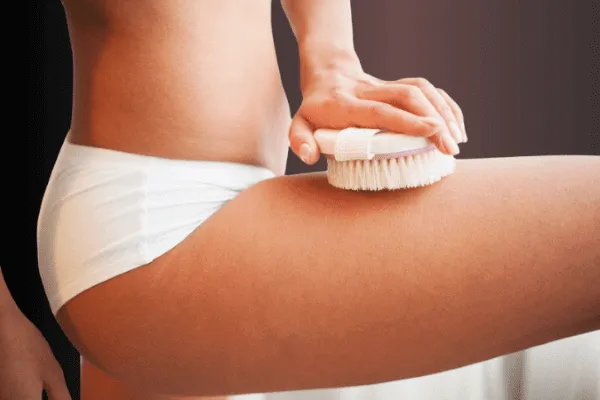 A woman skin brushes her leg.