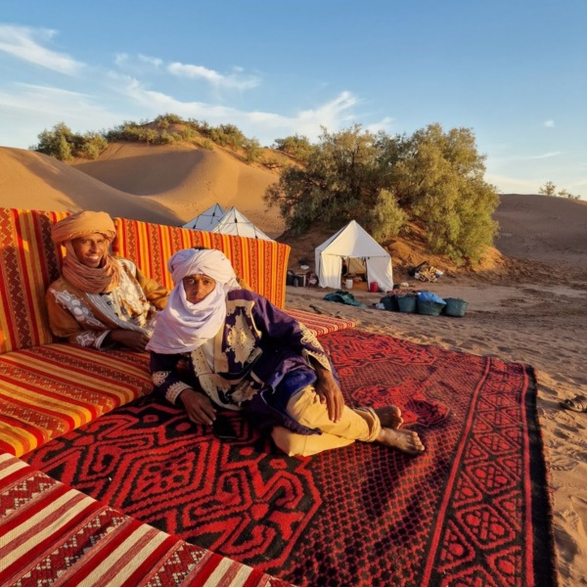 Berber-Guide mit Turban auf einem Teppich im Wüstencamp