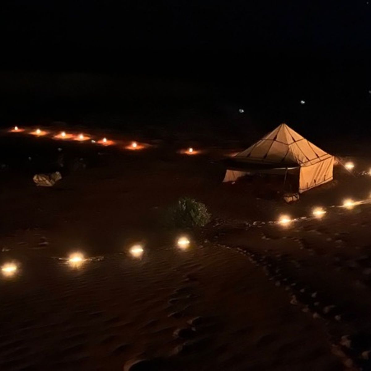 Wüstencamp bei Nacht mit Laternen im Sand