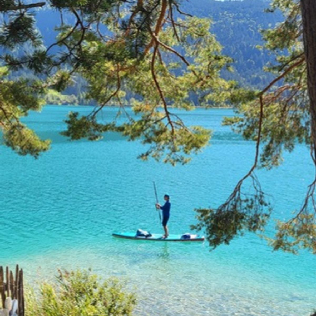 Standup Paddler im türkisen Weissensee