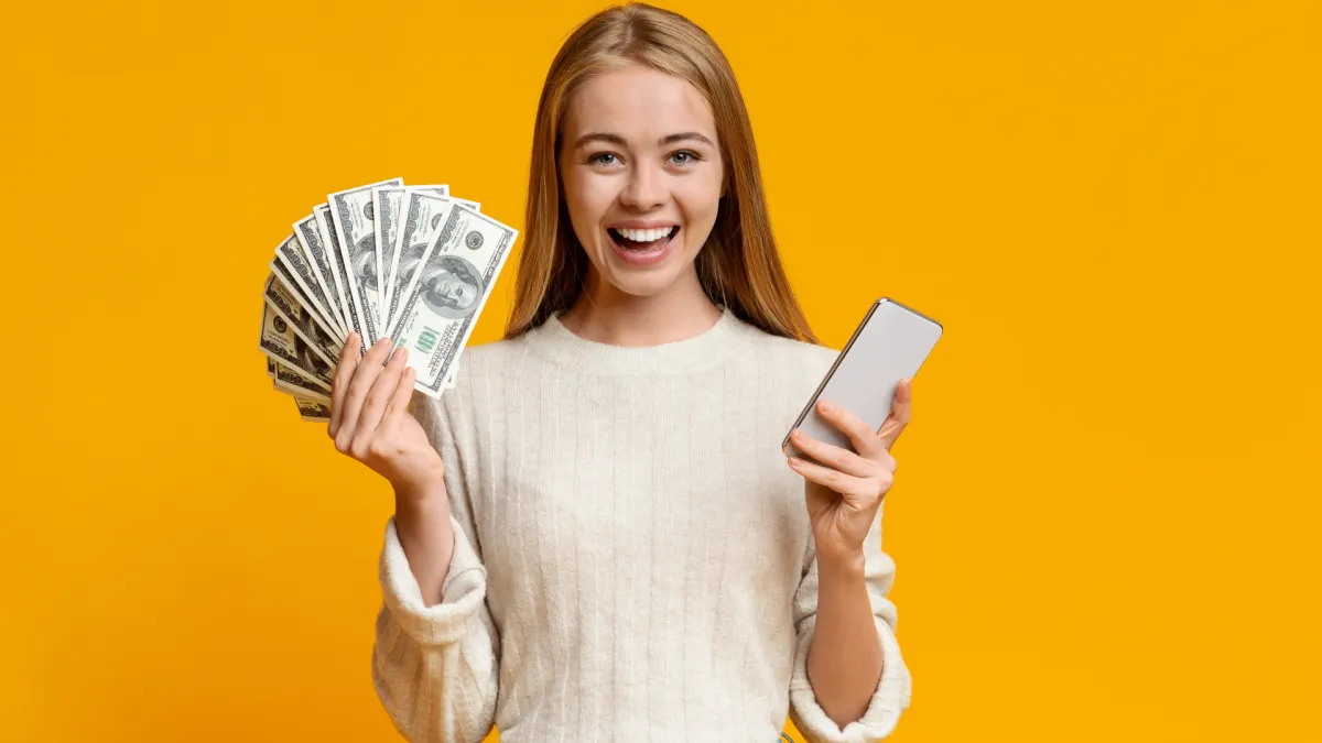 Happy girl with cash and a phone