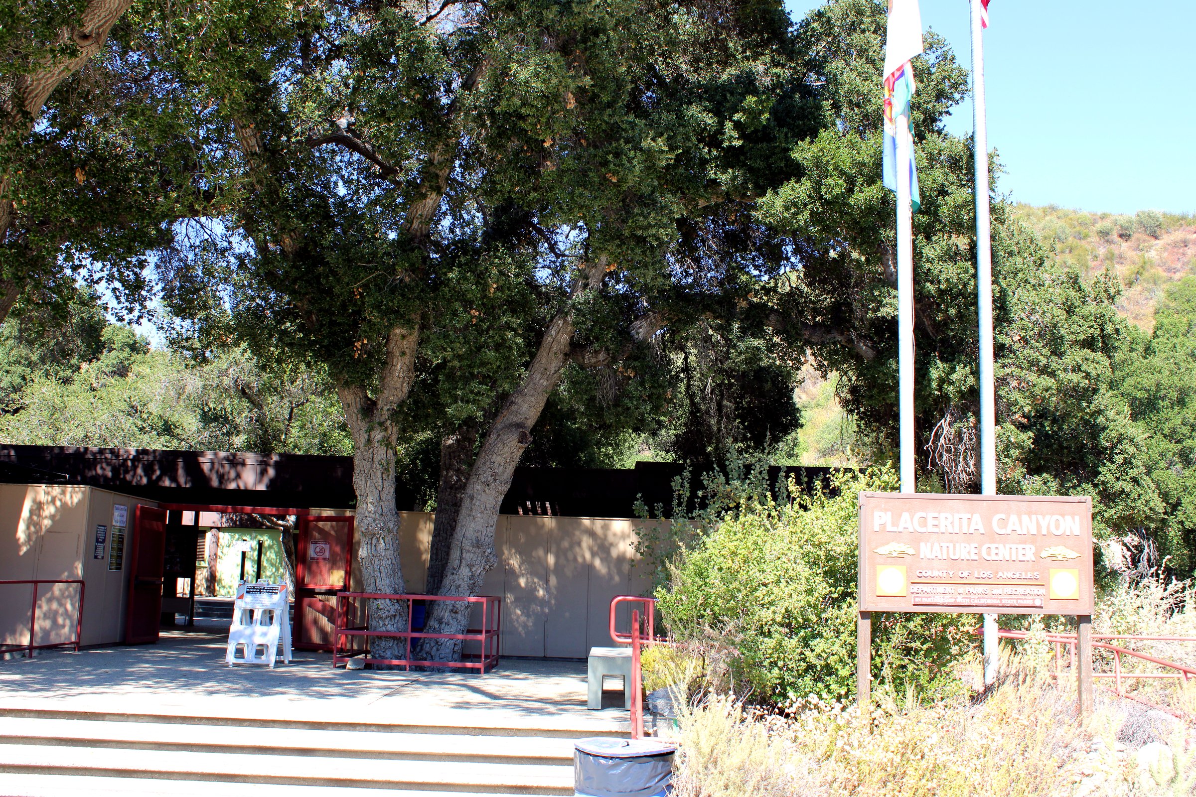 Placerita Canyon Nature Center entrance sign under oak trees in Newhall, Santa Clarita
