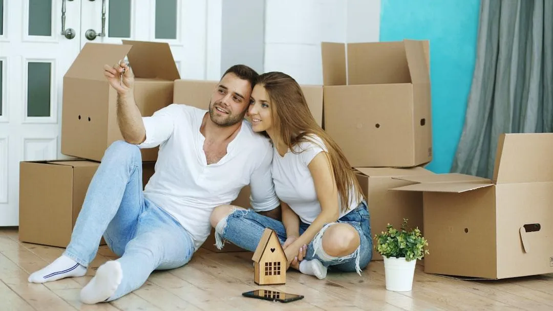 Home buyers sitting on floor with moving boxes showing fast yes-or-no decisions during showings.