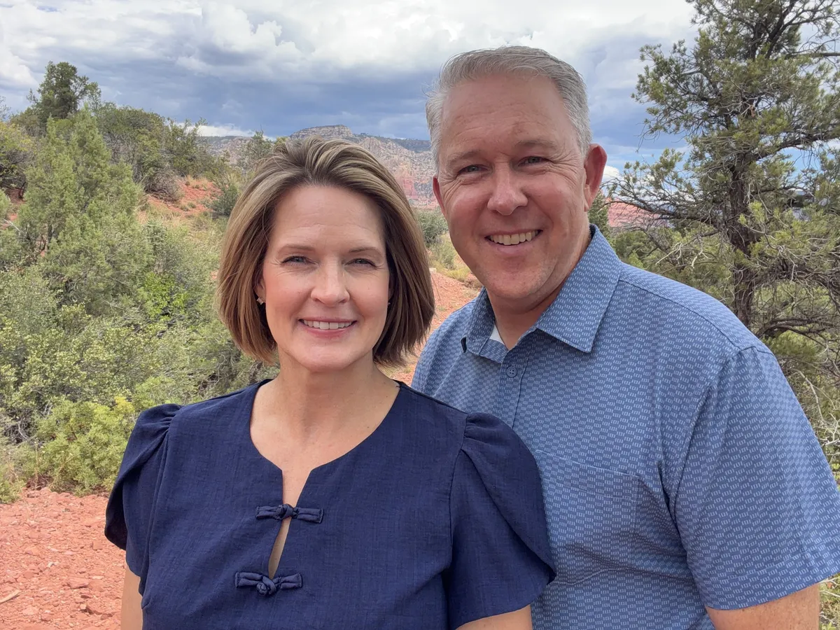 Cami and Greg Goucher, LIVIN In Sedona, standing in front of Sedona's red rocks