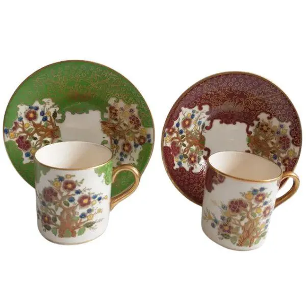 Soho Pottery Ambassador Ware demitasse cups and saucers, green and red with gold gilding and floral design.