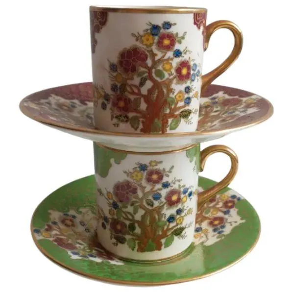 Soho Pottery Ambassador Ware demitasse cups and saucers, green and red with gold gilding and floral design.