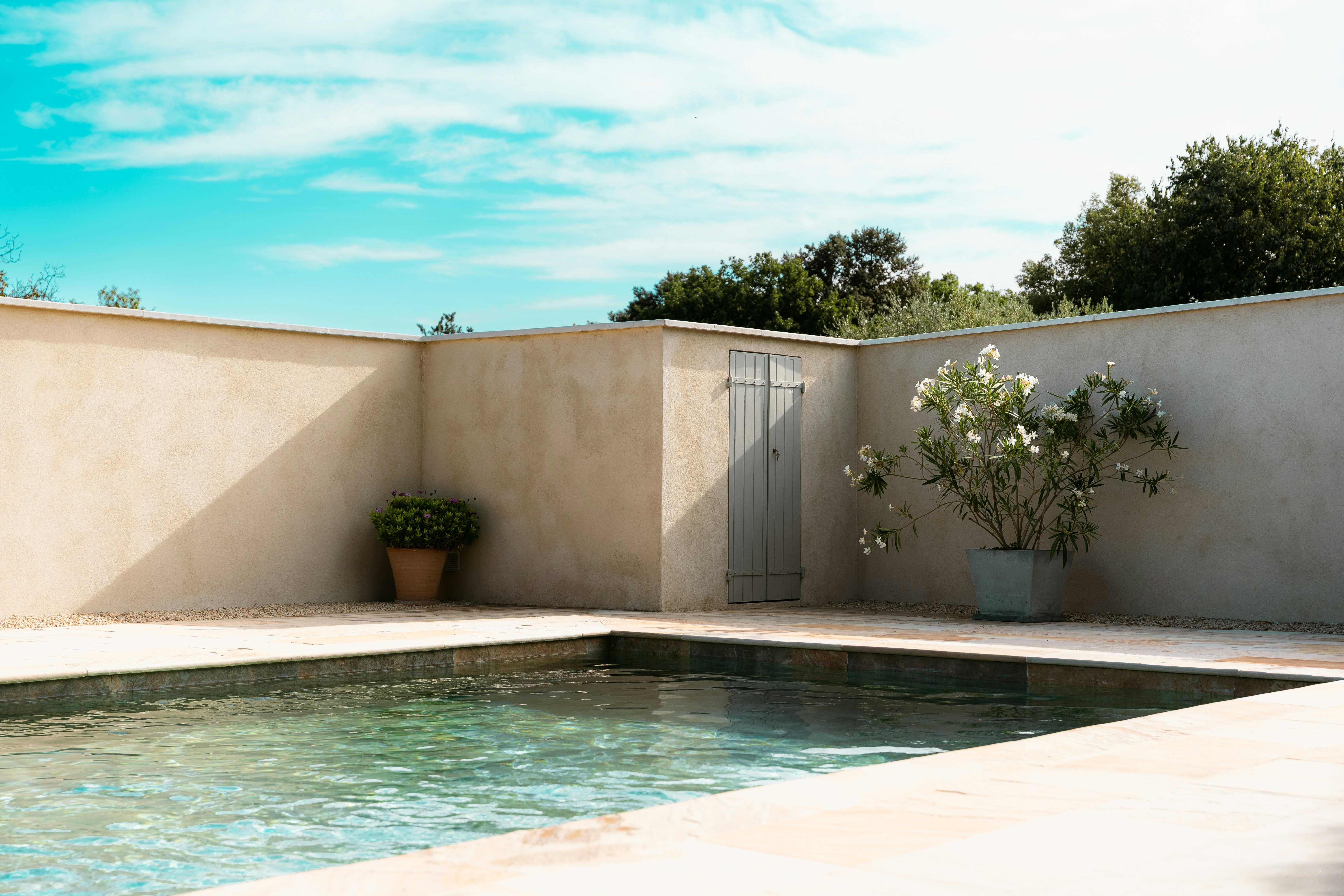 A photo of a pool and twoo plant boxes and a doorway