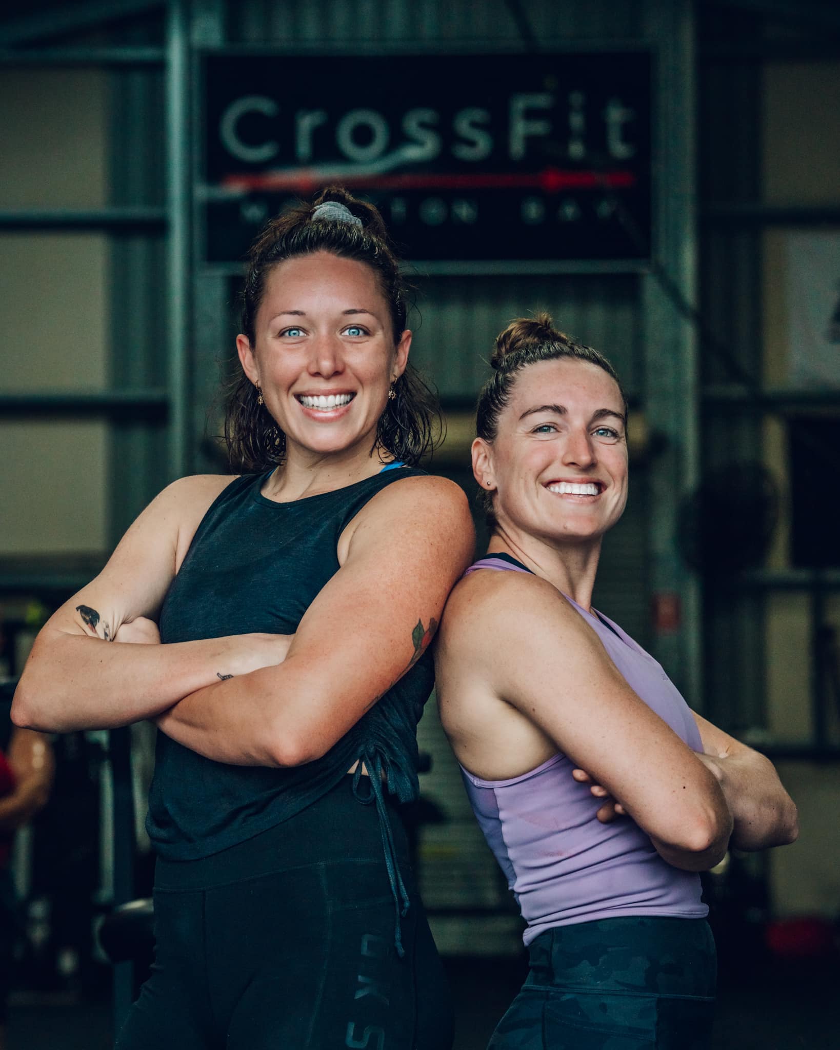 Man and woman performing kettlebell swings in gym.