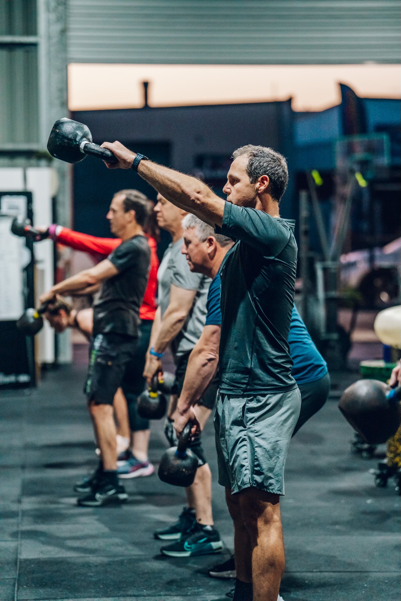 three person lifting barbels