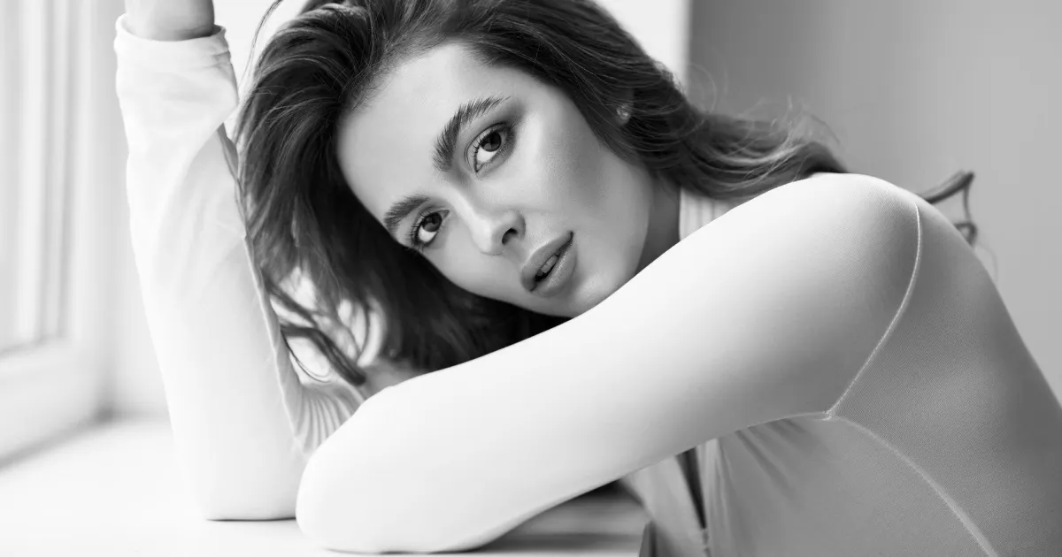 person holding clear glass bottle