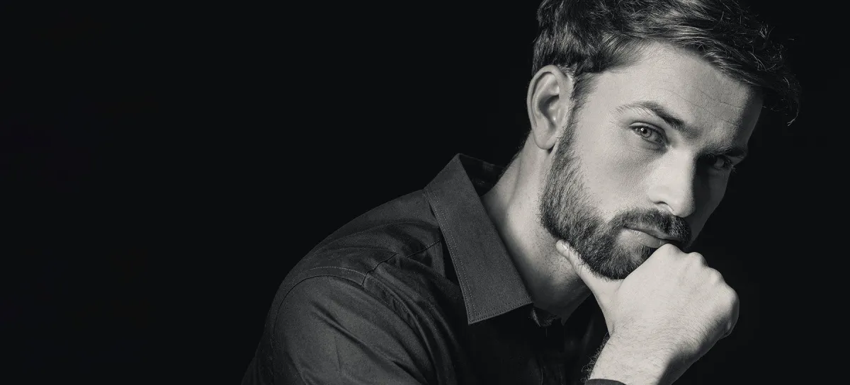 person holding clear glass bottle