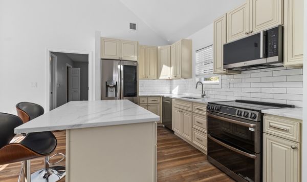 Modern tiny home or ADU kitchen with white countertops, custom cabinetry, and efficient small space design