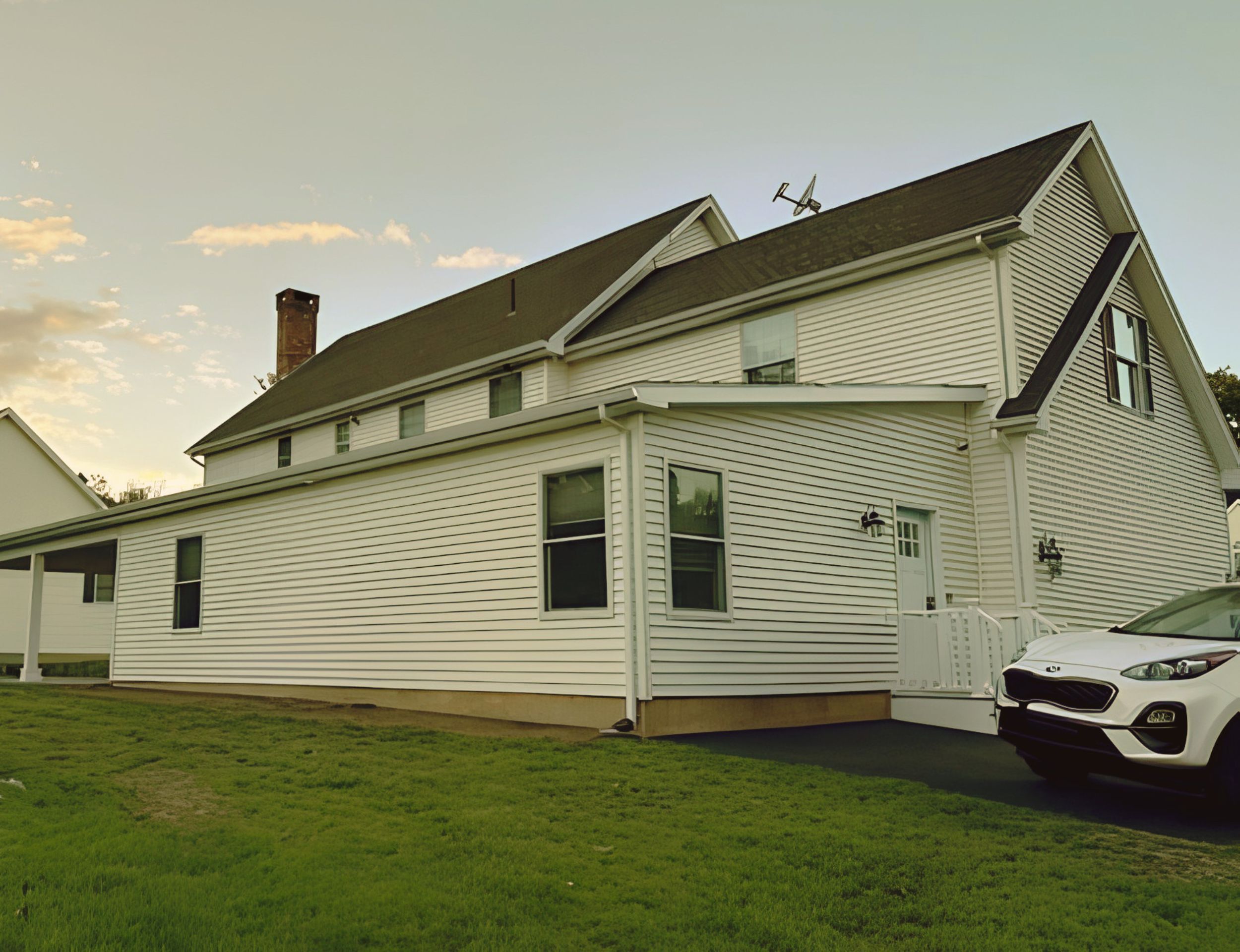 Completed white ADU home exterior with a lawn and driveway.