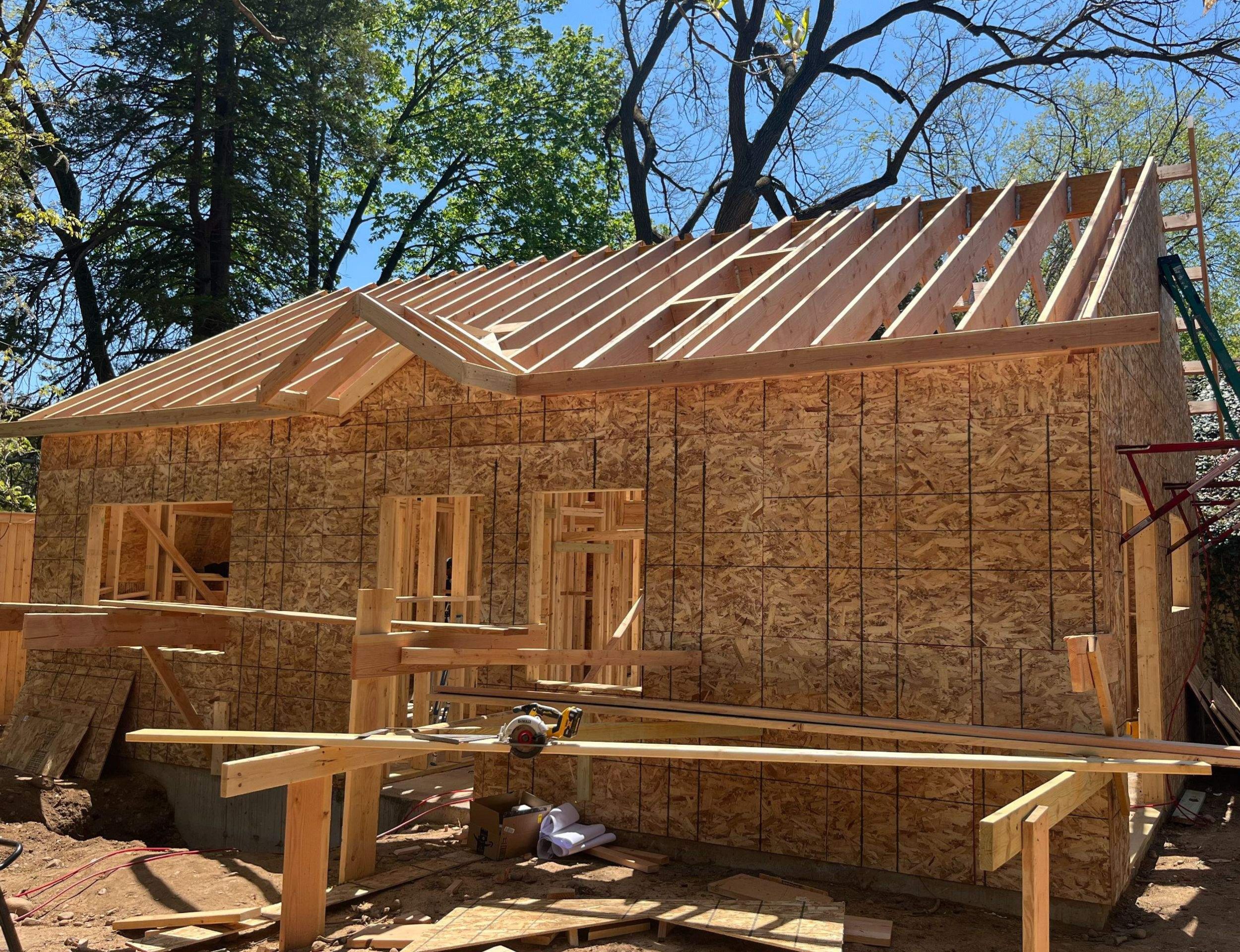 ADU under construction with exposed wood framing and roof rafters.