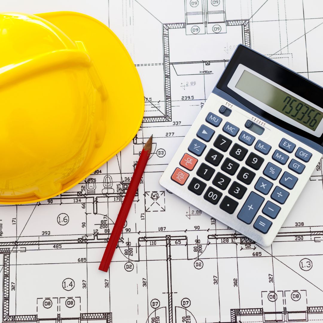 ADU cost planning with a hard hat, calculator, pencil, and construction blueprints.