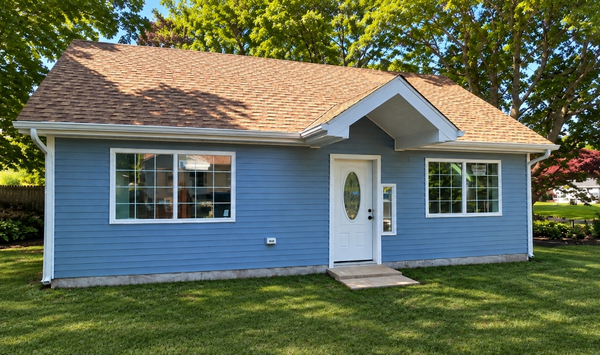 Blue single-story ADU with white trim, a front entry, and large windows.