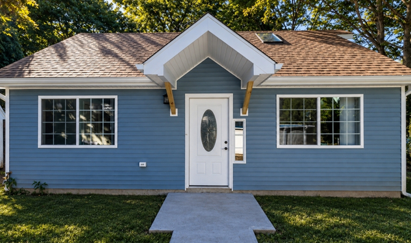 Blue single-story ADU with white trim, a front entry, and large windows.