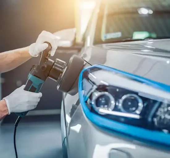 silbernes Auto, von vorne rechts, wird seitlich mit einem Poliergerät aufgearbeitet