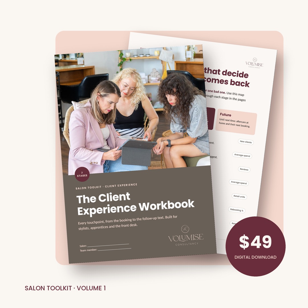 Mockup of 'The Client Experience Workbook' shown both printed and on a tablet screen. Cover features a photo of salon staff looking at a tablet together.