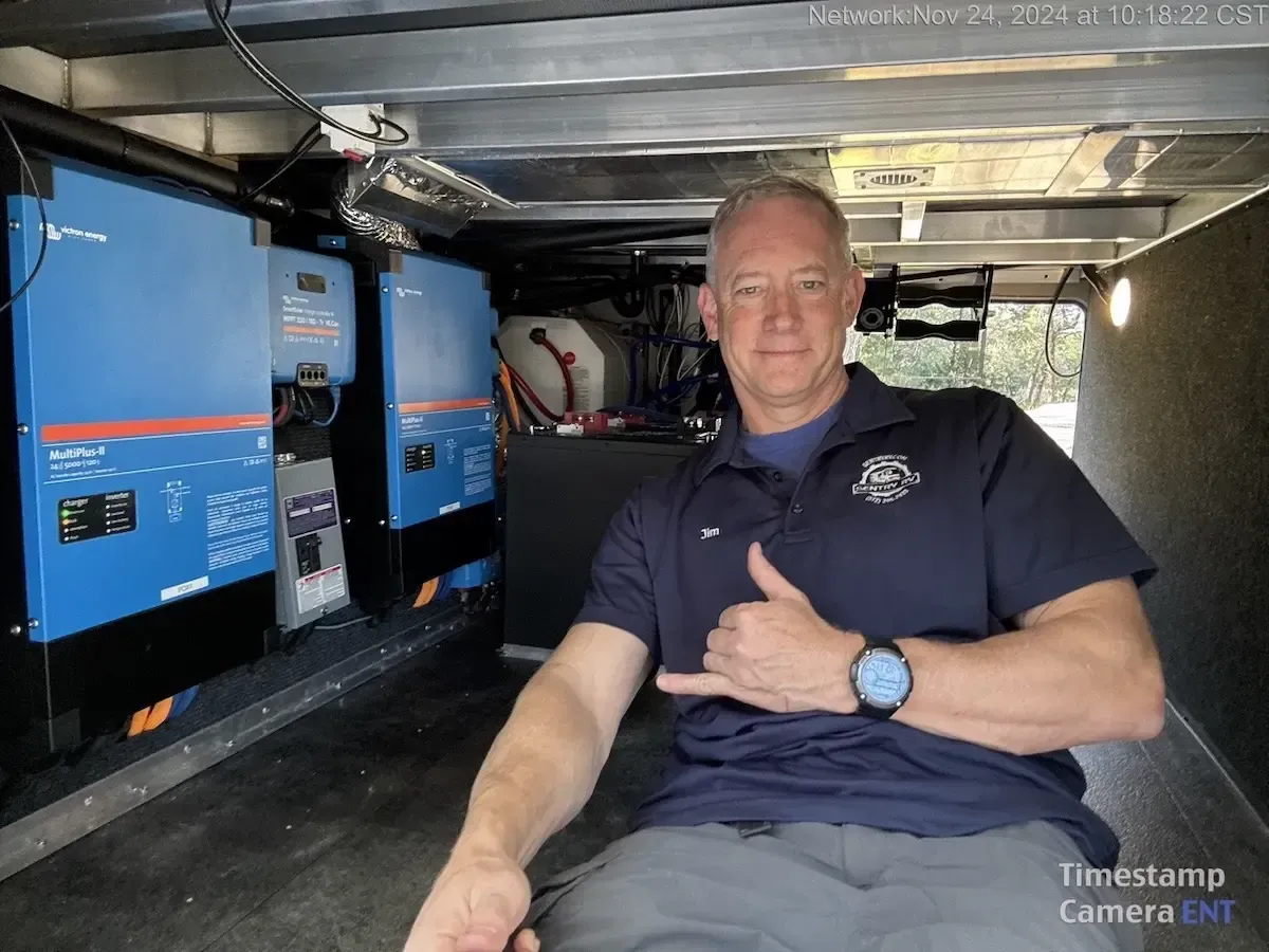 Man in a Sentry RV uniform giving a thumbs-up inside an RV, showcasing mobile repair equipment and emphasizing reliable service for RV inspections and maintenance.