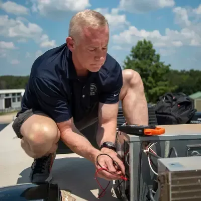 Technician performing RV air conditioning repair on rooftop, demonstrating mobile RV maintenance service.
