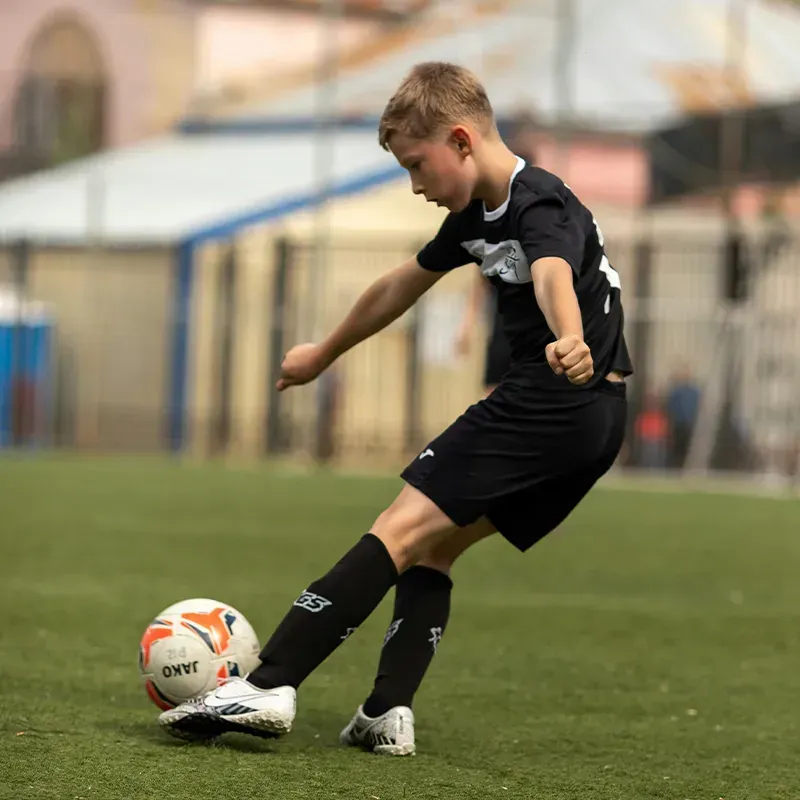 child u11-u13 action shot image at soccer game free kicking the ball