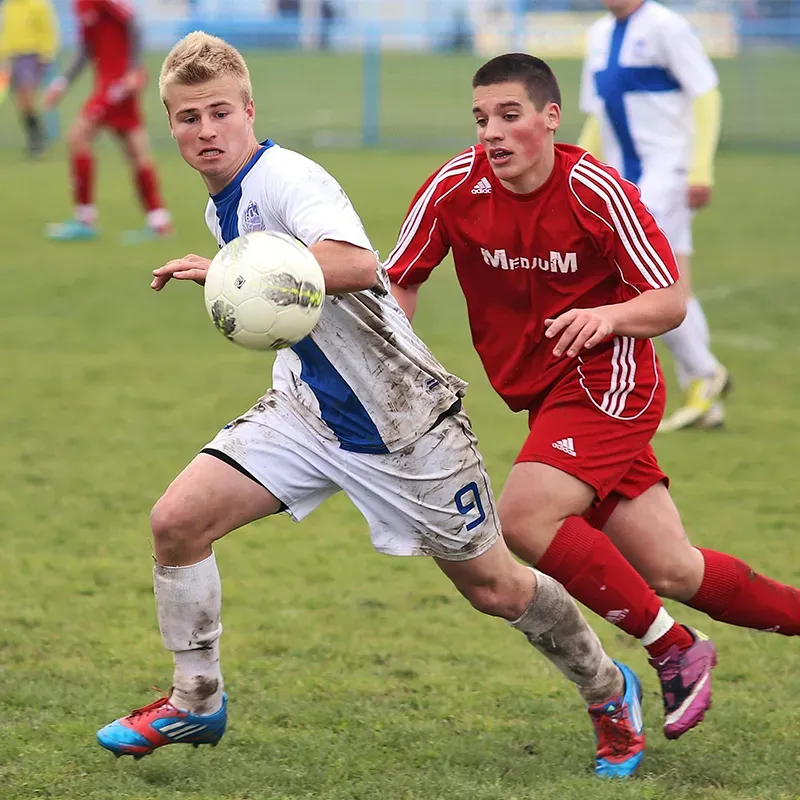 action shot picture of teenagers mid-soccer game