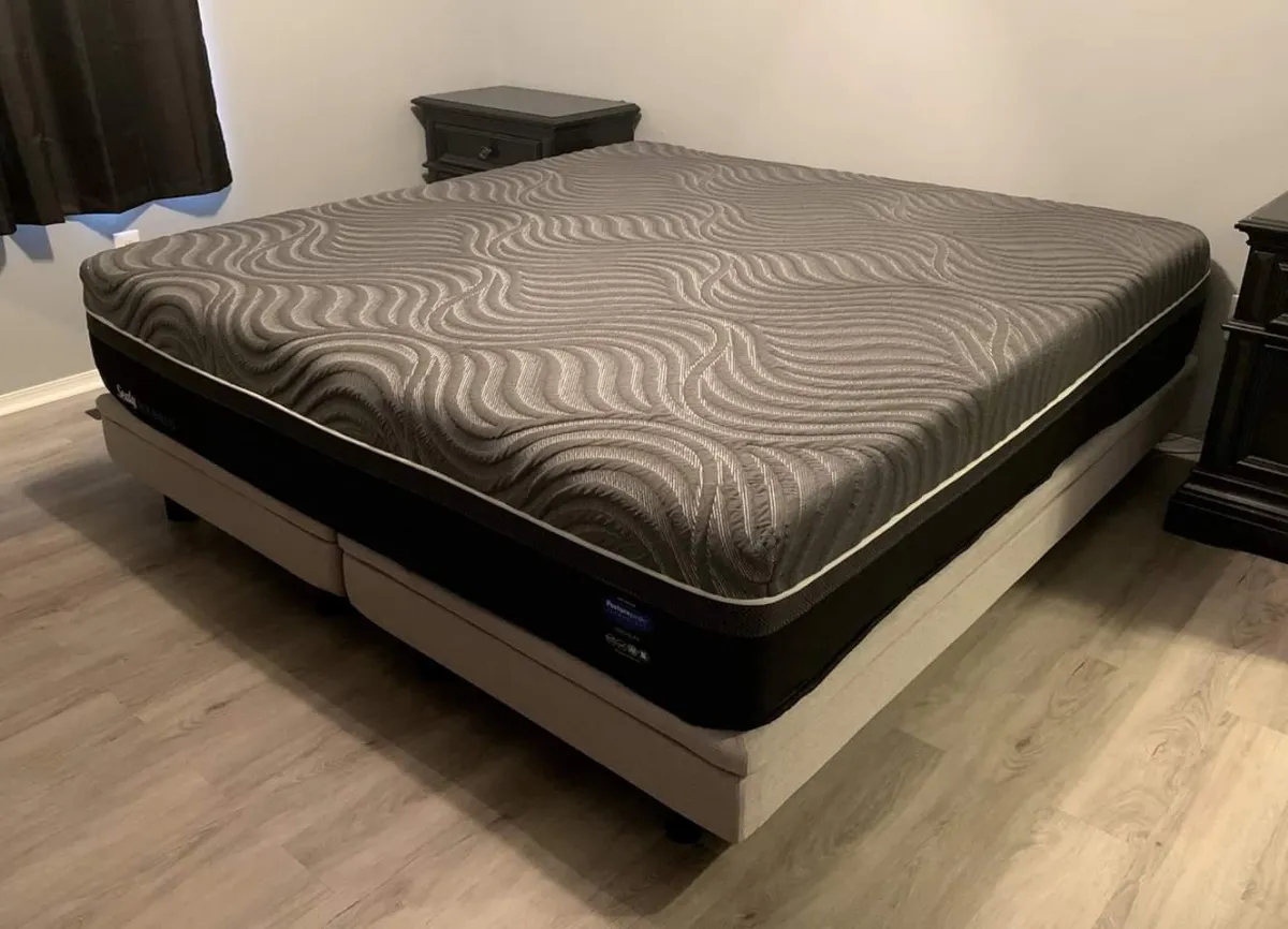 A black and grey gel memory foam hybrid mattress made by Sealy.