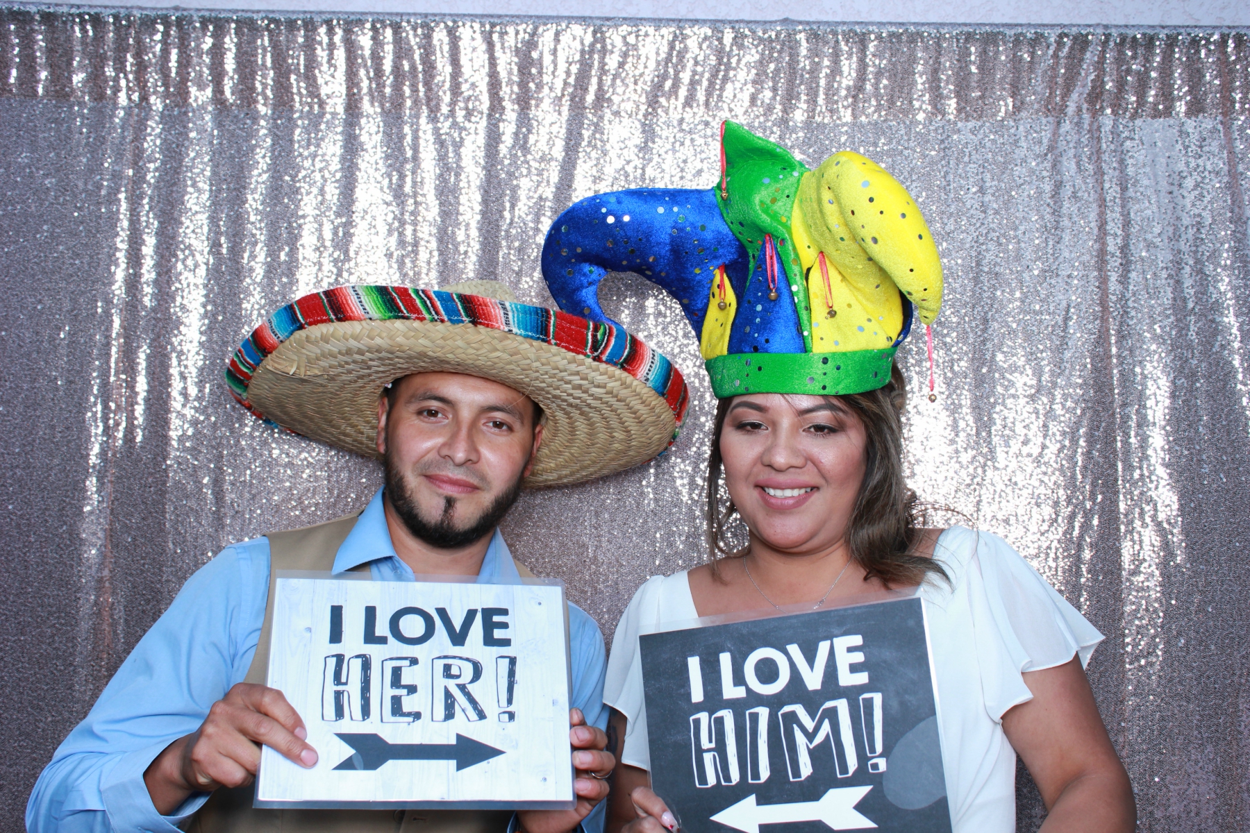 Wedding couple posing with fun love signs at reception photo booth